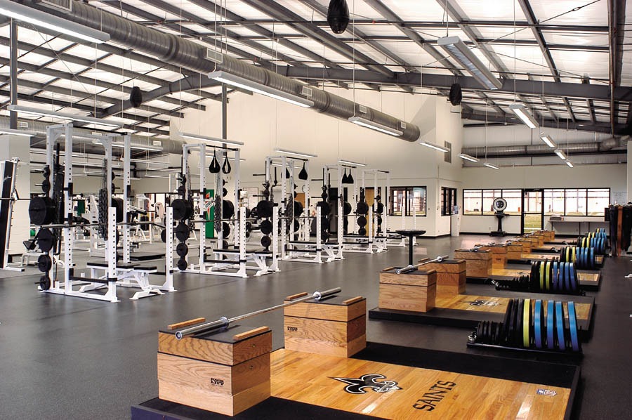 Interior of a modern athletic training facility with weight racks, lifting platforms, and strength equipment.Interior of a modern athletic training facility with weight racks, lifting platforms, and strength equipment.